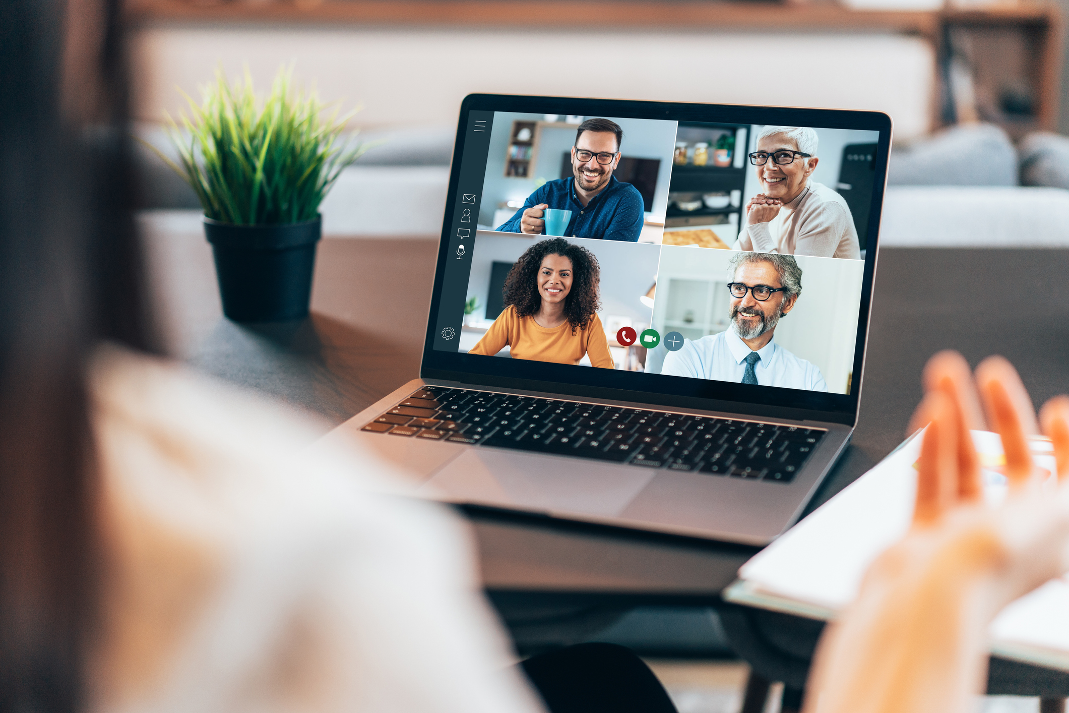 Over the shoulder shot of person using a laptop with video conference app