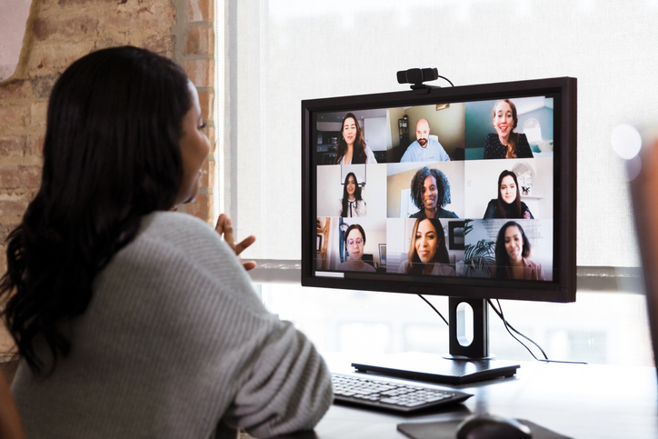A multi-ethnic team of co-workers meet together via video conferencing.