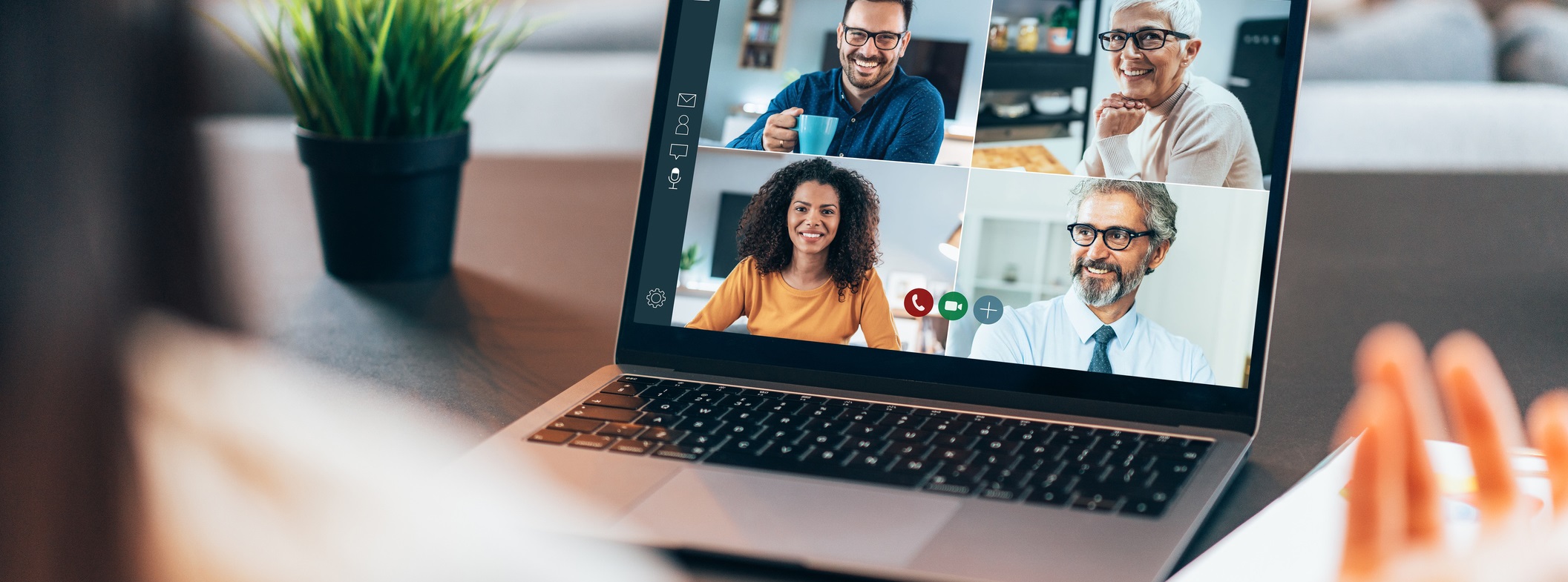 Over the shoulder shot of person using a laptop with video conference app